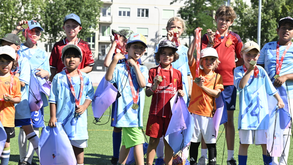 Children celebrate with medals after an InterSoccer Summer Football Camp.