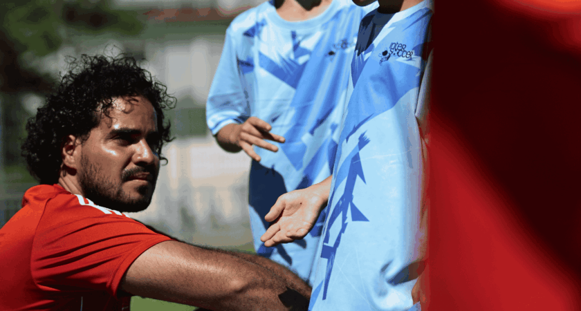 Summer football camp safety at InterSoccer, with a coach checking on young players during a sunny break.