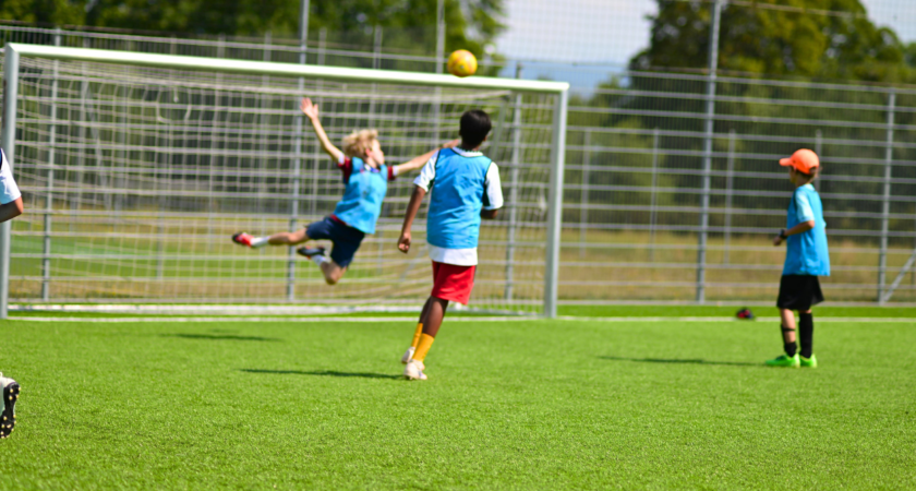 Young player jumping for the ball during an InterSoccer Autumn Football Course trial