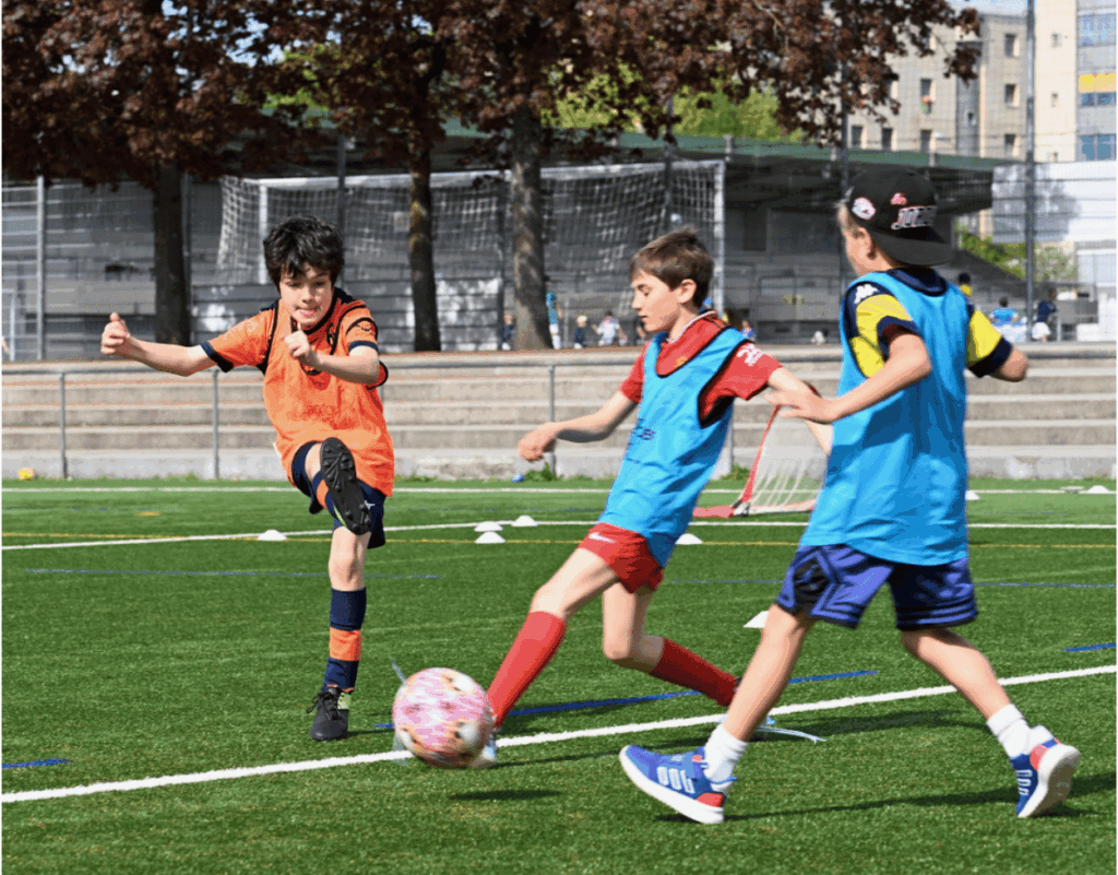 Children playing football at an InterSoccer Geneva Summer Camp