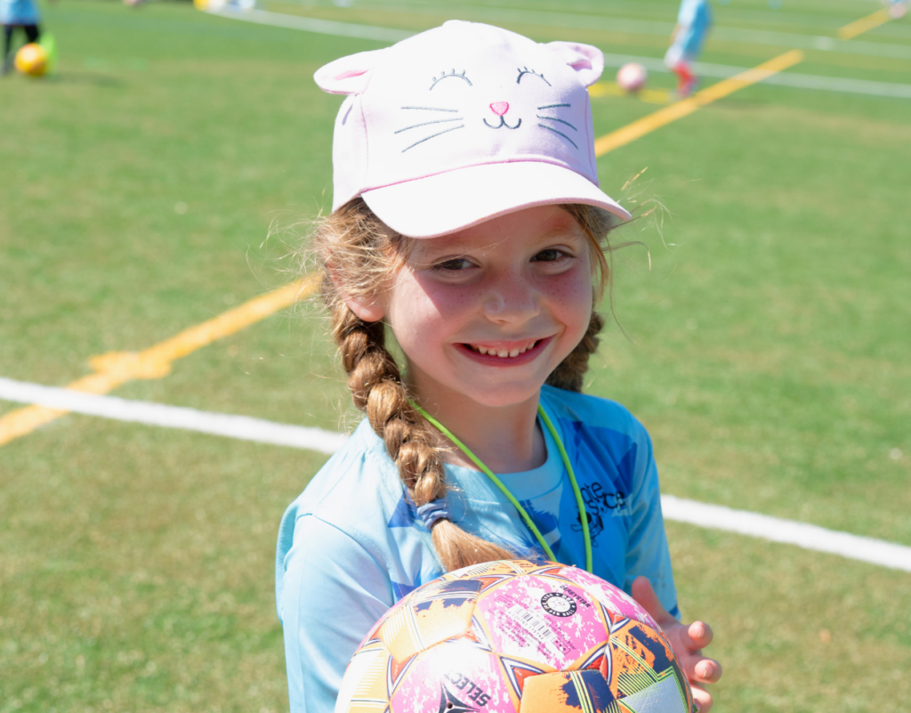 Girl holding a football at an InterSoccer course in Geneva