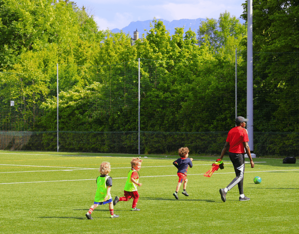 Young children playing with the coach during an InterSoccer Mini Camp