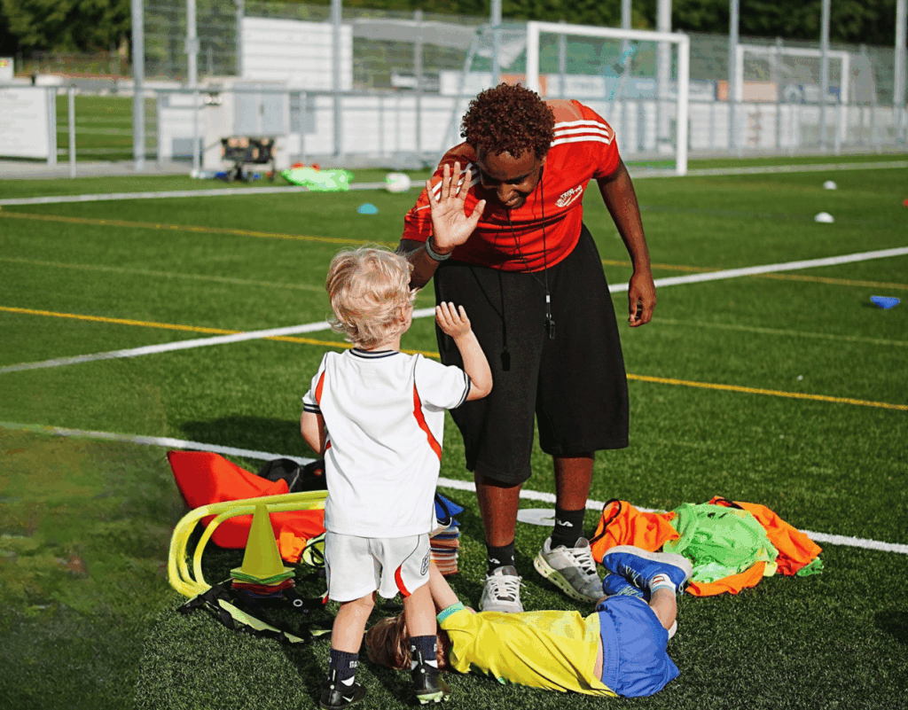 Child giving high five to a coach at InterSoccer Football Camp